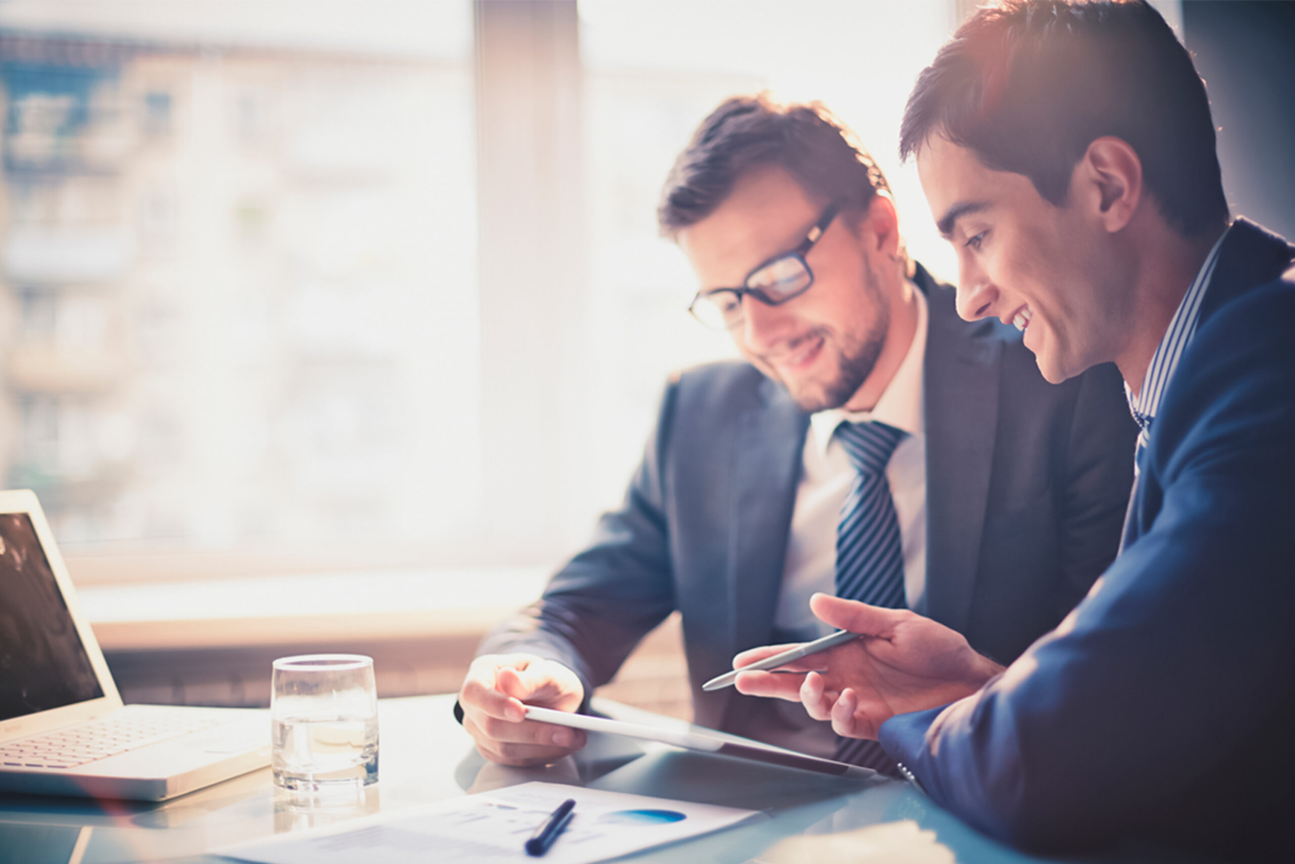 two-men-are-sitting-table-one-them-is-looking-tablet